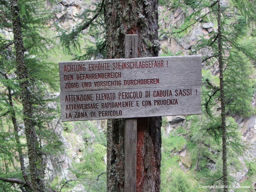 Oft weisen Schilder auf Steinschlaggefahr hin (deutsch und italienisch)